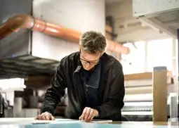 a man in workshop studying some documents