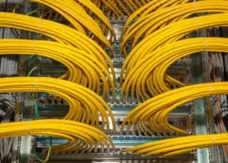 lots of yellow network cables plugged into server rack